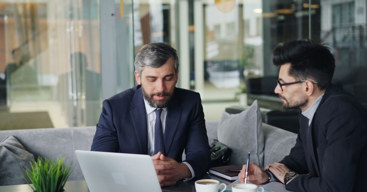 Consultants technologiques en réunion de travail avec schémas sur tableau blanc