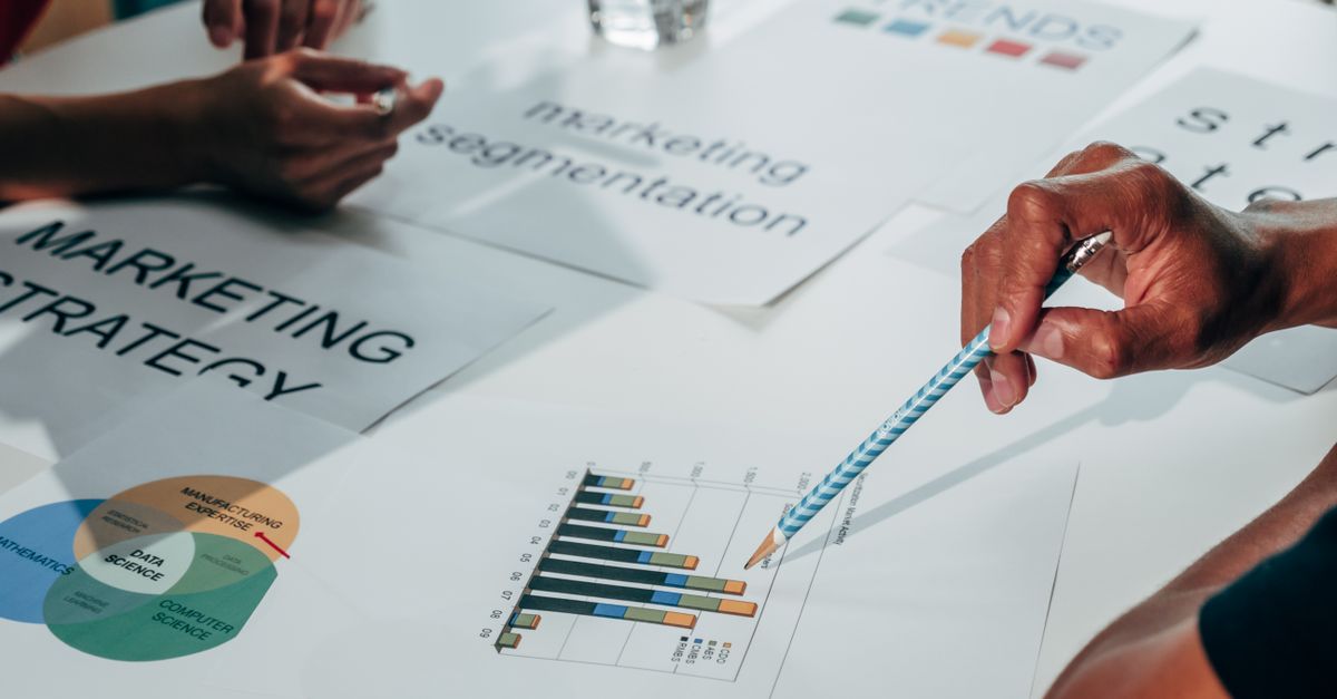 Tableau de segmentation client avec post-its et schémas marketing sur un mur d'agence
