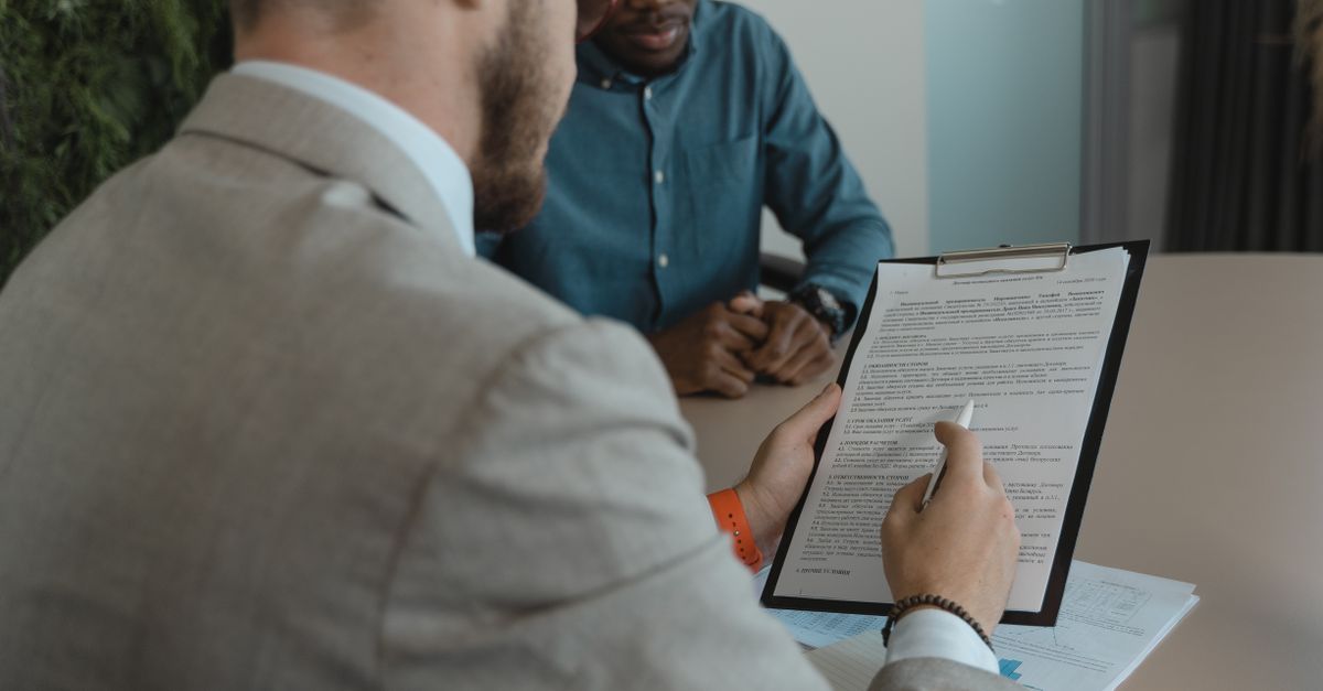 Recruteur examinant un dossier de candidature finance avec notes et tableur