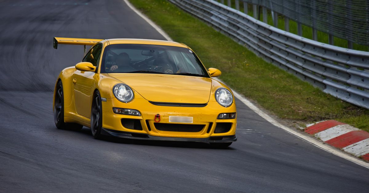 Porsche 911 garée devant un circuit automobile, incarnant le prestige et la performance durable